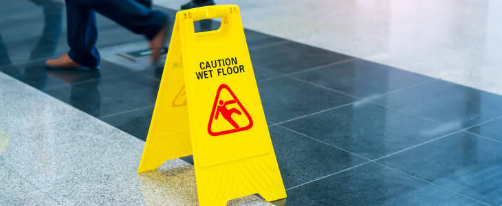 Caution Wet Floor sign on the floor of a building.